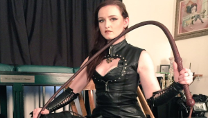 Vivienne l’amour en tenue noire avec une présence dominante dans un décor brut